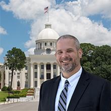 Photo of Andrew McClure with Alabama state capitol in background